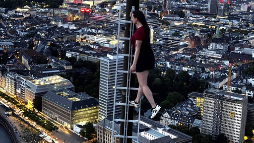Eine Influencerin posiert auf dem Düsseldorfer Rheinturm 