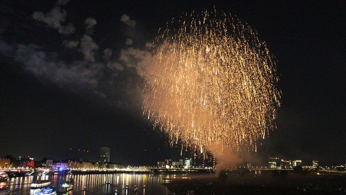 In der Dunkelheit leuchtet Feuerwerk über dem Rhein