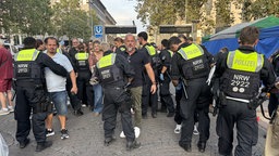 Mehrere Polizeibeamte tasten in der Altstadt Düsseldorf die Besucher ab - ähnlich wie bei der Stadionkontrolle
