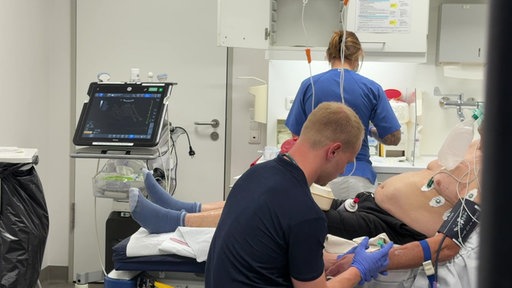 Ein Arzt und eine Krankenpflegerin behandeln einen Mann in der Notaufnahme