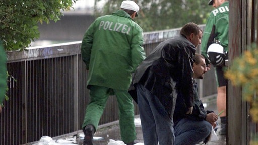 Der Tatort des Wehrhahn-Anschlags im Jahr 2000. Polizisten suchen nach Spuren.