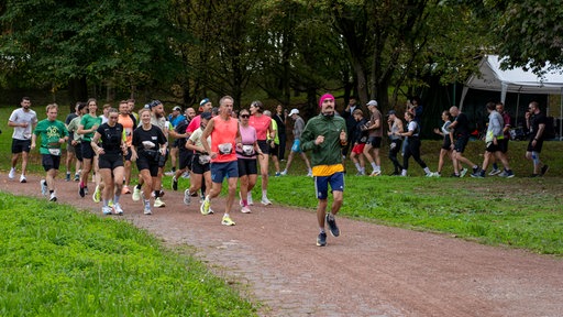 Läufer in Sportkleidung auf einem Schotterweg