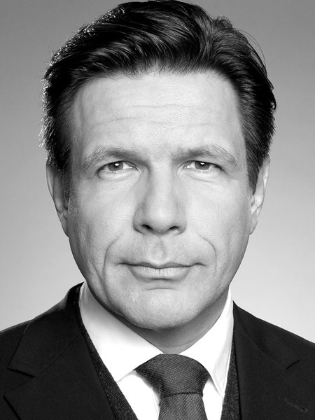 Ein Mann im Anzug schaut in die Kamera