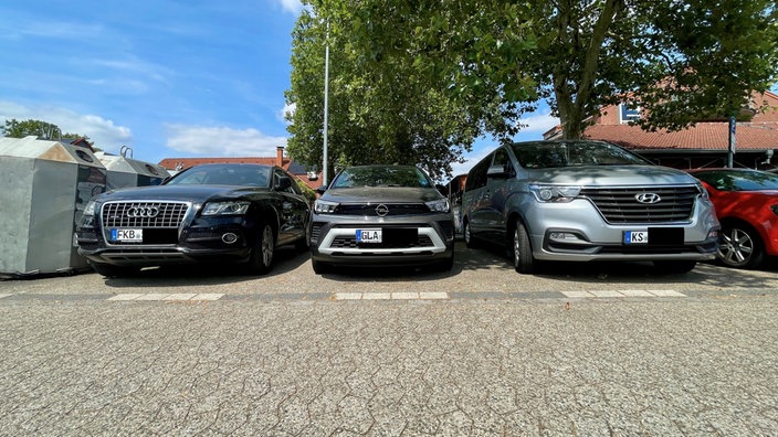 Autos mit auswärtigen Kennzeichen stehen auf einem Parkplatz in Düsseldorf Lichtenbroich