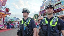 Zwei Polizisten. Sie sind auf der Kirmes.