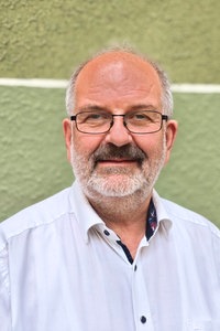 Ein Mann mit Brille schaut in die Kamera.