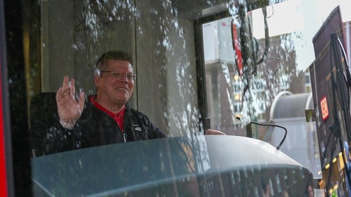 Rhienbahnfahrer Guido Esser winkt durch die Frontscheibe der Rheinbahn.