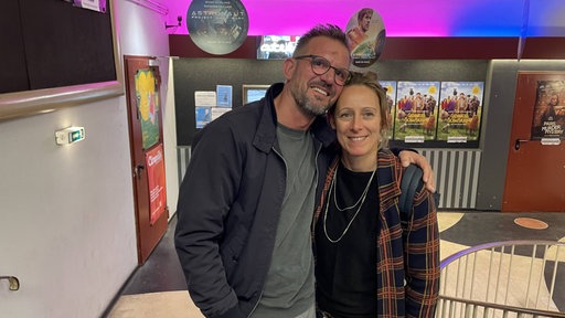 Mann und Frau lachen in die Kamera