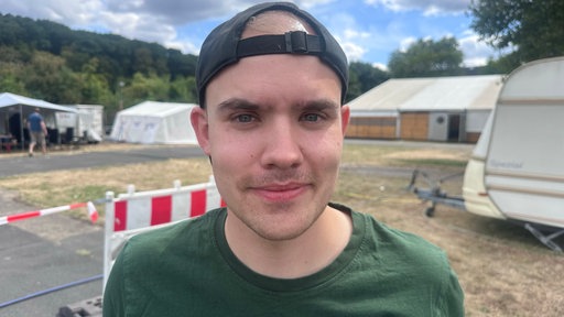 Tobias Glöck, Geschäftsführer der Rather Schützen, ist im Porträt zu sehen. er steht auf dem Platz, auf dem das Schützenfest am Samstag stattfindet.