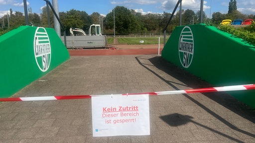 Die Bezirkssportanlage in Düsseldorf-Garath ist dicht: An einem Eingang hängt ein Schild an einem Flatterband mit der Aufschrift: "Kein Zutritt. Dieser Bereich ist gesperrt."