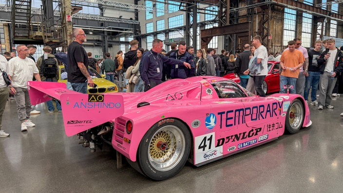 Ein leuchtend pinker Rennwagen steht in einer Halle beim Tuning-Treffen "Ultrace" in Düsseldorf