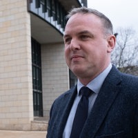 Ein Mann mit schwarzer Krawatte steht vor dem Düsseldorfer Landtag