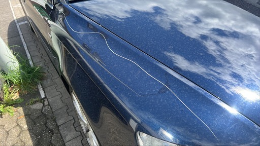 Ein langer Kratzer auf der Motorhaube eines Autos