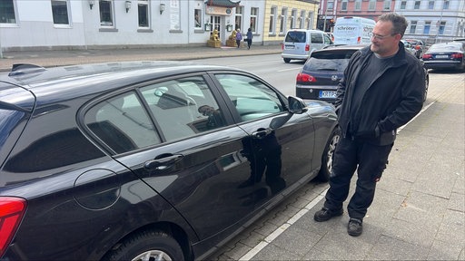 André Ergardt neben einem zerkratztem Auto in Krefeld