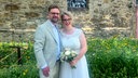 Sascha Fitting und Miriam Uehren aus Bochum stehen in Hochzeitskleidung vor einer Kirche.