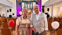 In einer Tracht und Weste heiratet ein älteres Pärchen. Der Raum ist festlich geschmückt.