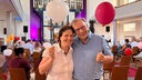 Grinsend stehen Gaby Küpper und Eberhard Wegener  mit zwei herzförmigen Luftballons in der Kirche.