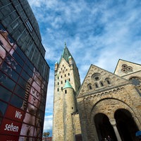Der Dom in Paderborn vor einem blauen, bewölkten Himmel.