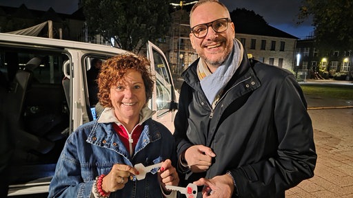 WDR2 Moderatorin Steffi Neu und Stephan Rinke, Direktor der VHS Essen halten die Schlüssel für das WDR2 Glashaus in die Kamera