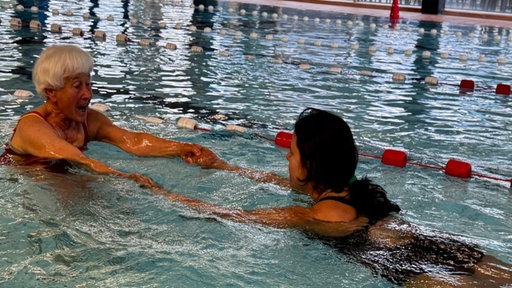 Schwimmlehrein Ruth Petter mit Ankit Kumar im Schwimmbecken beim Training für das Seepferdchen