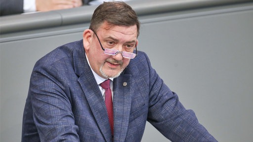 Knuth Meyer-Soltau steht mit den Händen auf ein Podium gestützt.