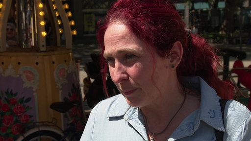 Eine Frau mit roten Haaren steht in der Innenstadt
