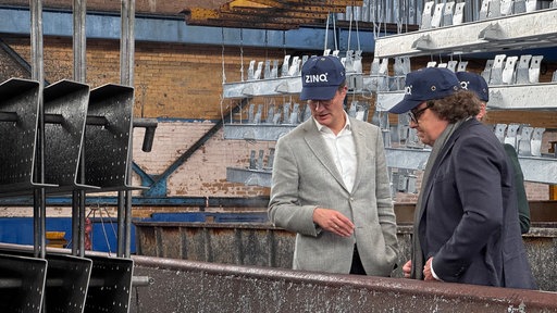 Ministerpräsident Hendrik Wüst beim Gespräch in einer Industriehalle