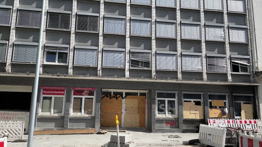 Altes leerstehendes Gebäude mit Graffiti beschmiert. Fenster und Tür sind mit Holzplatten zugenagelt