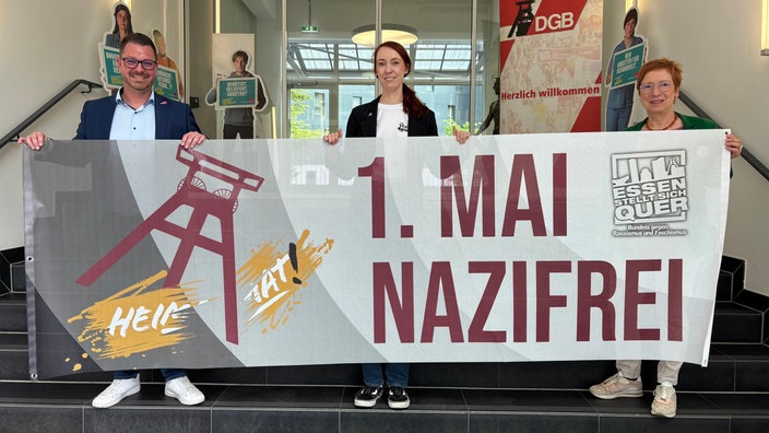 Ein Banner für die Gegendemo am 1. Mai wird präsentiert