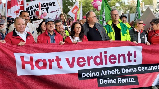 Menschen halten ein Banner bei einer DGB Kundgebung in Essen