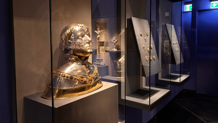Reliquien aus Gold hinter Glaskästen im blauen Ausstellungsraum der Domschatzkammer