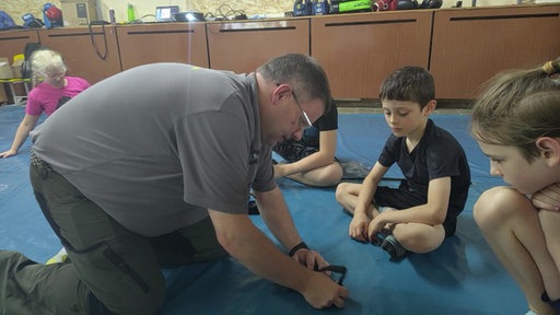 Marc Friedrich zeigt Kindern, wie sie amputierte Gliedmaßen behandeln.