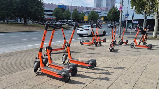 Sehr viele Leih-Scooter stehen ungeordnet auf einem Gehweg nahe des Einkaufszentrums Limbecker Platz in Essen.