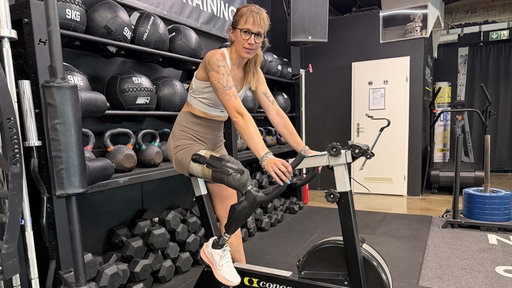 Janine Rähl sitzt auf einem Indoor-Bike im Fitness-Center
