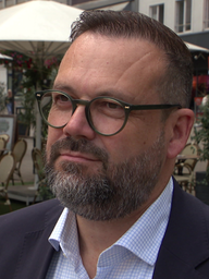 Alexander Brambrink steht in der Essener Innenstadt vor einem Lokal.