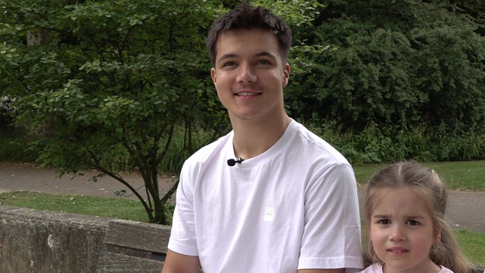 Das Bild zeigt einen Teenager und ein kleines Mädchen.