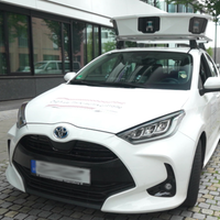 Ein weißer Wagen parkt in einer Straße mit Kameras auf dem Dach