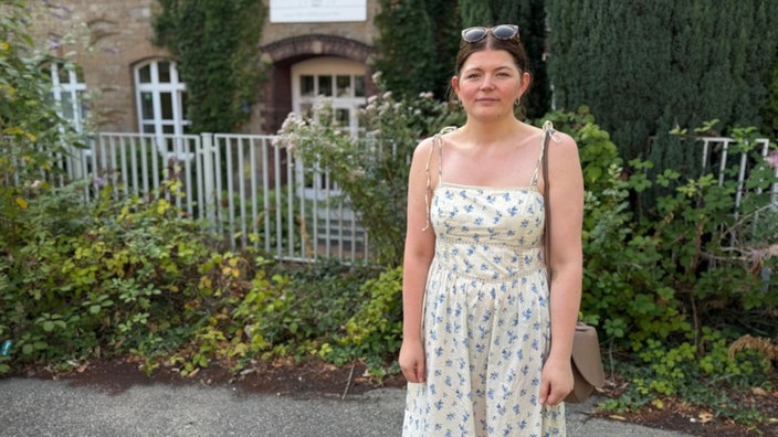 Eine Frau steht vor einem Gebäude