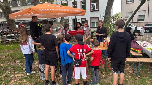 Kinder stehen an für Popcorn beim Spielplatzfest von Kray ist bunt