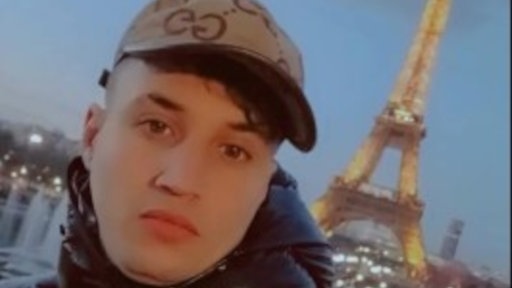 Ein junger Mann vor dem Eiffelturm.
