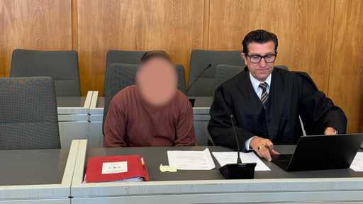 Der 28-jährige Angeklagte sitzt links neben seinem Verteidiger auf der Anklagebank im Essener Landgericht