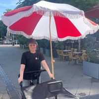Streetworkerin Emeli Kaebler schiebt einen Bollerwagen gefüllt mit Sonnencreme und Wasser
