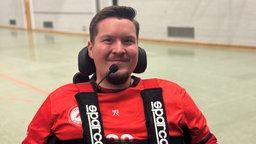 Spieler Lars Dyringer sitzt in seinem Rollstuhl und lächelt 