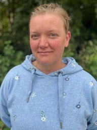Johanna Lohkämper in einem blauen Kapuzenpulli in ihrem Garten