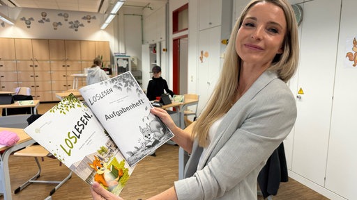 Lehrerin Tanja Thurau zeigt Schulmaterialien