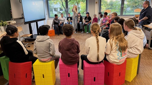 Schüler sitzen im Morgenkreis zusammen