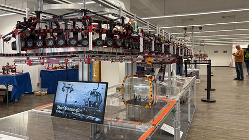 Ein komplexest Rollensystem mit einer kleinen Seilbahngondel ist zu sehen.