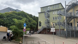 Gebäude der Drogensuchthilfe in Essen, davor stehen einige Menschen unter einem Baum und vor einer Treppe