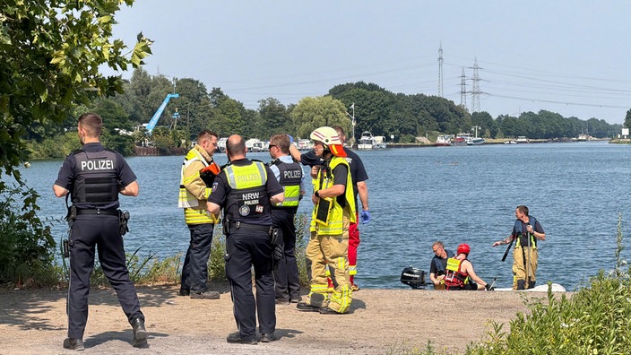 Polizei und Feuerwehr vor dem Wasser