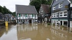 En Platz in Solingen steht unter Wasser, um das Wasser herum stehen Häuser und ein Briefkasten